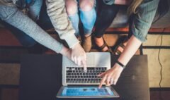 three person pointing the silver laptop computer